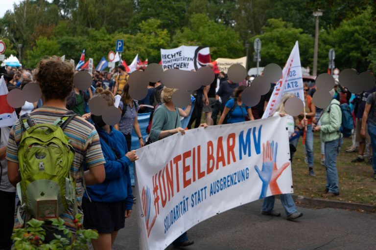 Eine Gruppe Menschen trägt ein Banner von Unteilbar