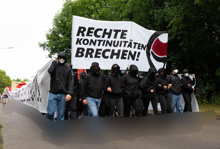 Die Front des antifaschistischen Blockes ist zu sehen. Es wird ein großes Transparent mit der Aufschrift "Rechte Kontinuitäten brechen" hochgehalten