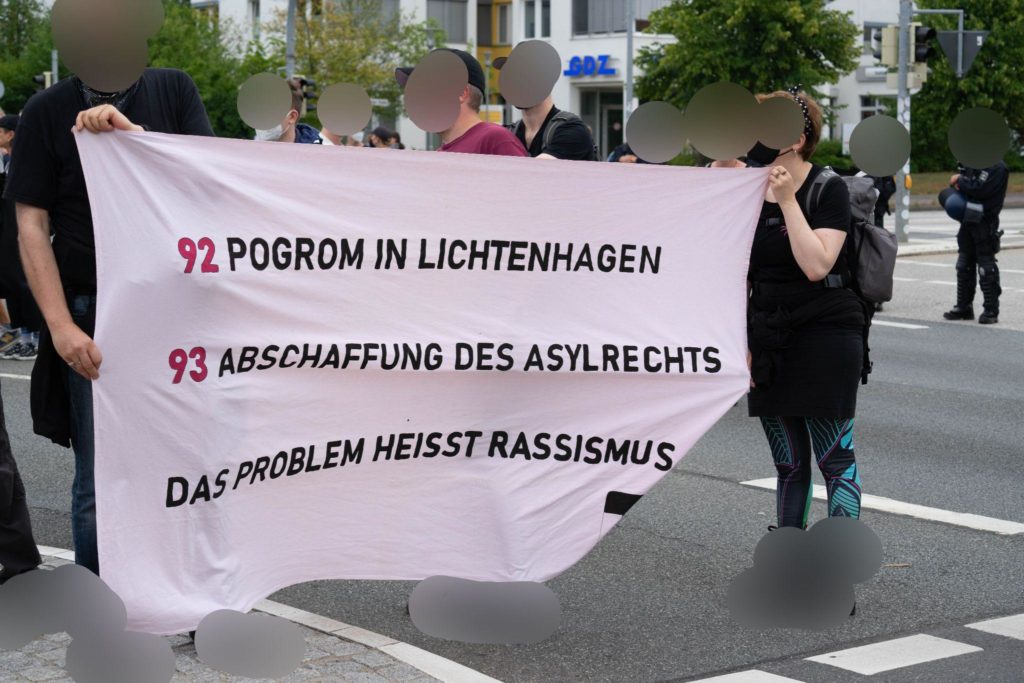 Ein Transparent mit der Aufschrift: "92 Pogrom in Lichtenhagen, 93 Abschaffung des Asylrechts, Das Problem heißt Rassismus"